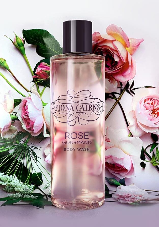 Fiona Cairns Rose Gourmand body wash bottle shot on a floral background. Branding and packaging design by Andsome Ltd