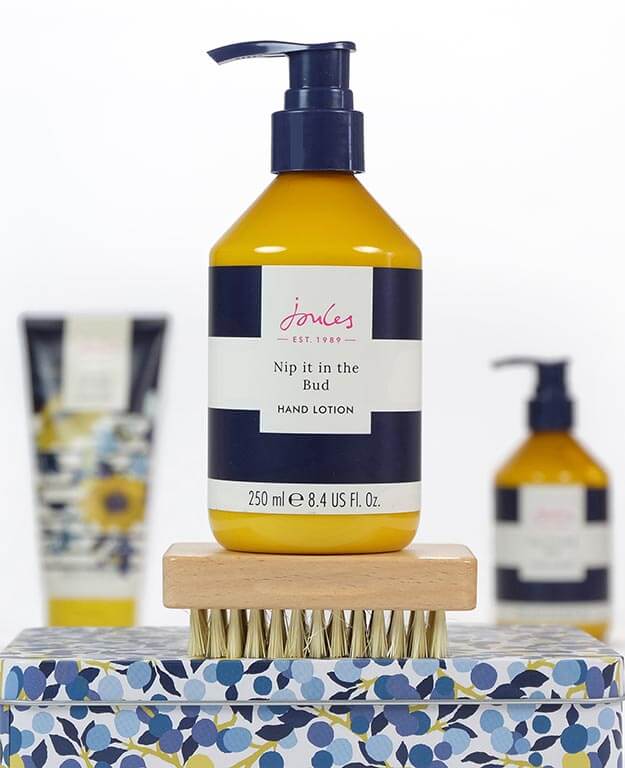 Joules all year round indulgent bathing products. Hand lotion balanced on nail brush.